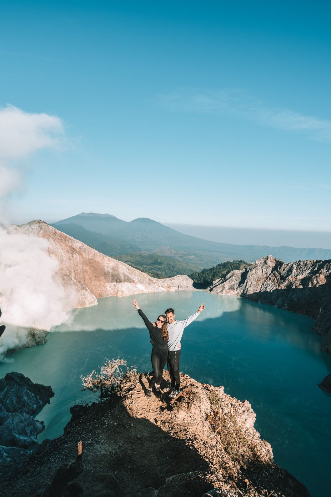 A couple enjoying the view at the turquoise Ijen Crater lake.