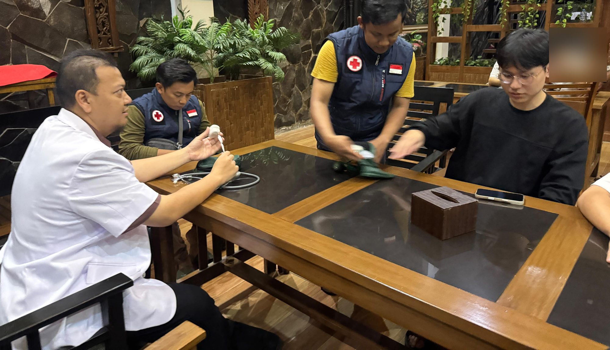 Preview: Dr. Ahmad Irwandanu and two assistants prepare the pulse oximeter and blood-pressure cuff before a guest's Ijen pre-ascent screening at Baratha Hotel, Bondowoso.